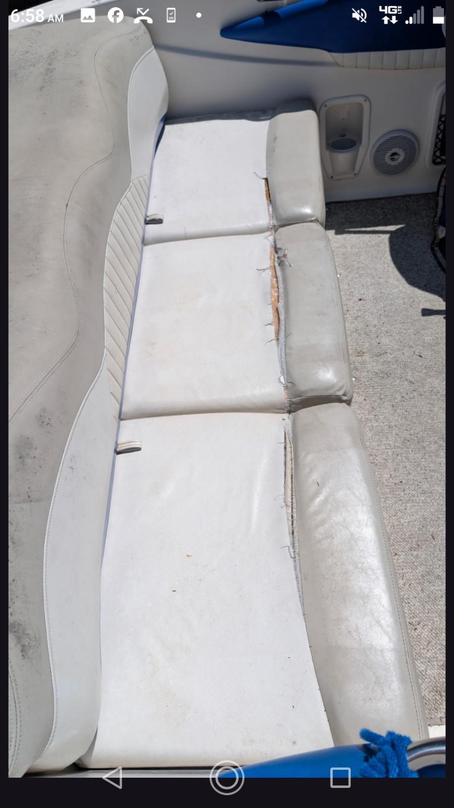 Worn vinyl boat seat with torn seams before reupholstery