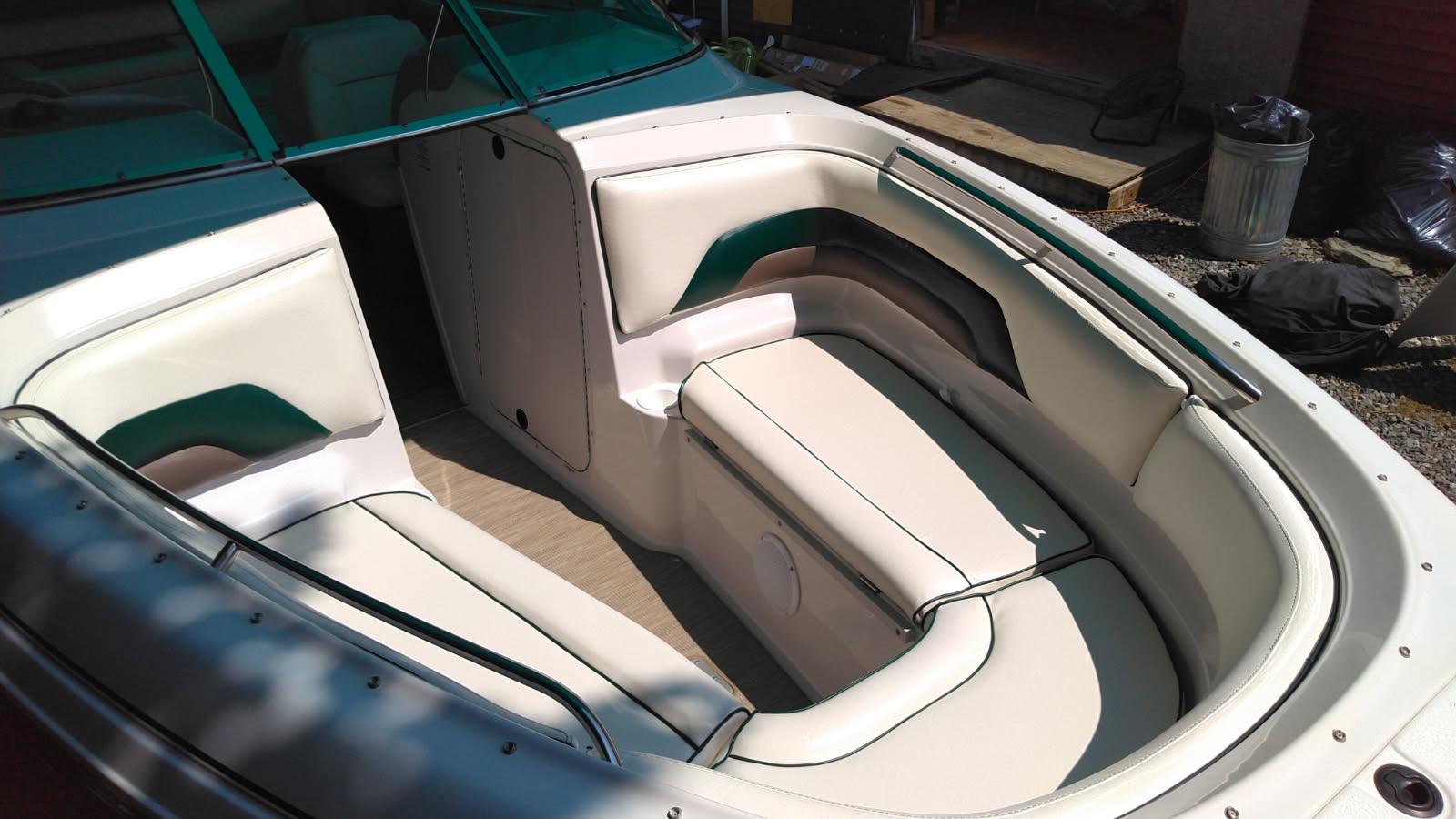 Elevated view of the finished bow cockpit with white vinyl seating, green piping, and woven vinyl flooring