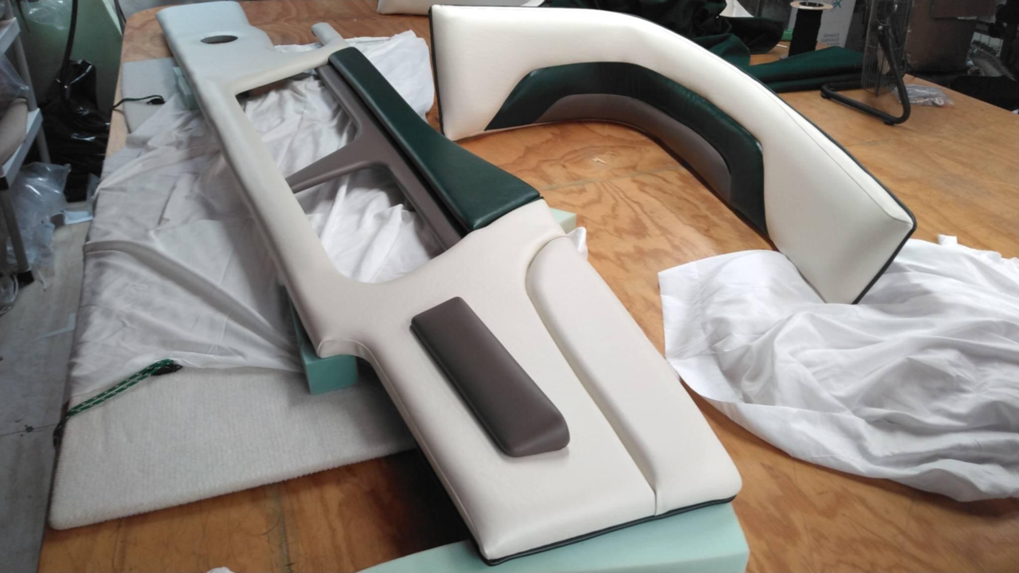 White, dark gray, and green marine vinyl panels being fitted during the restoration